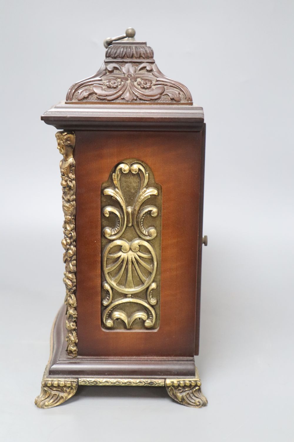 A German ornately carved and brass mounted mantel clock, height 34cm